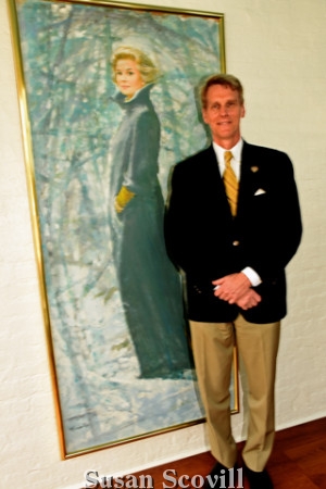 9. J.B. Kelly paused for a photo with Grace Kelly's portrait.