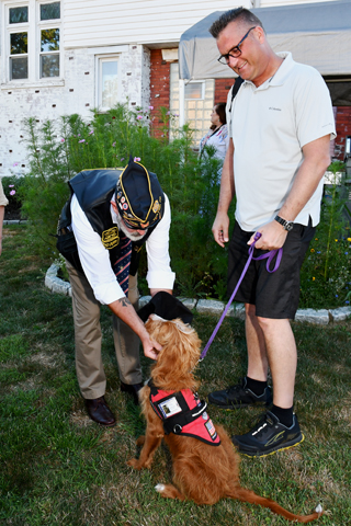  4. Past Commander Scott Carlson greeted Tails of Honor Puppy, Barney a Lapradoodle puppy, and Brian Hausknecht during the event 