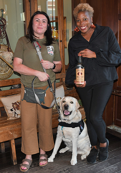 1. Alpha Brava Canine Puppy Raising Director, Tracy Ruepp, and 'Debin' the Community Outreach Dog, paused for a photo with Krystal Williams, PR agent for Tito's Vodka
